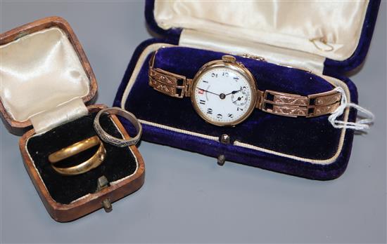 A ladys 9ct gold wrist watch, on a 9ct bracelet and three rings, 22ct, 18ct and stamped silver.